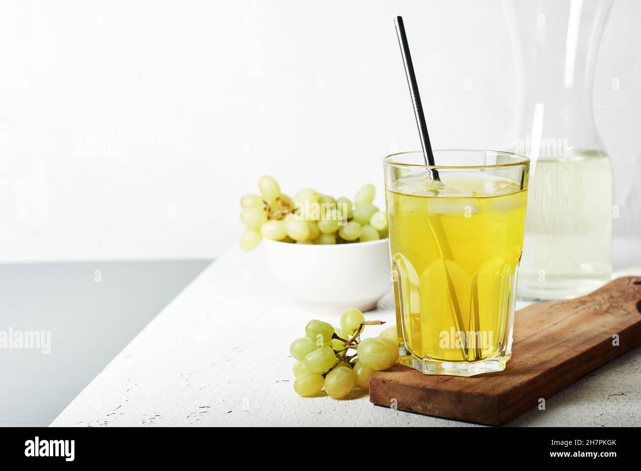 Ein Glas Traubensaft und ein paar weiße Trauben. Stockfoto