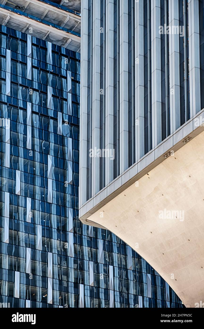Vor einem neuen Wolkenkratzer in Seattle steht ein altes Bürogebäude auf einem Betonsockel. Stockfoto