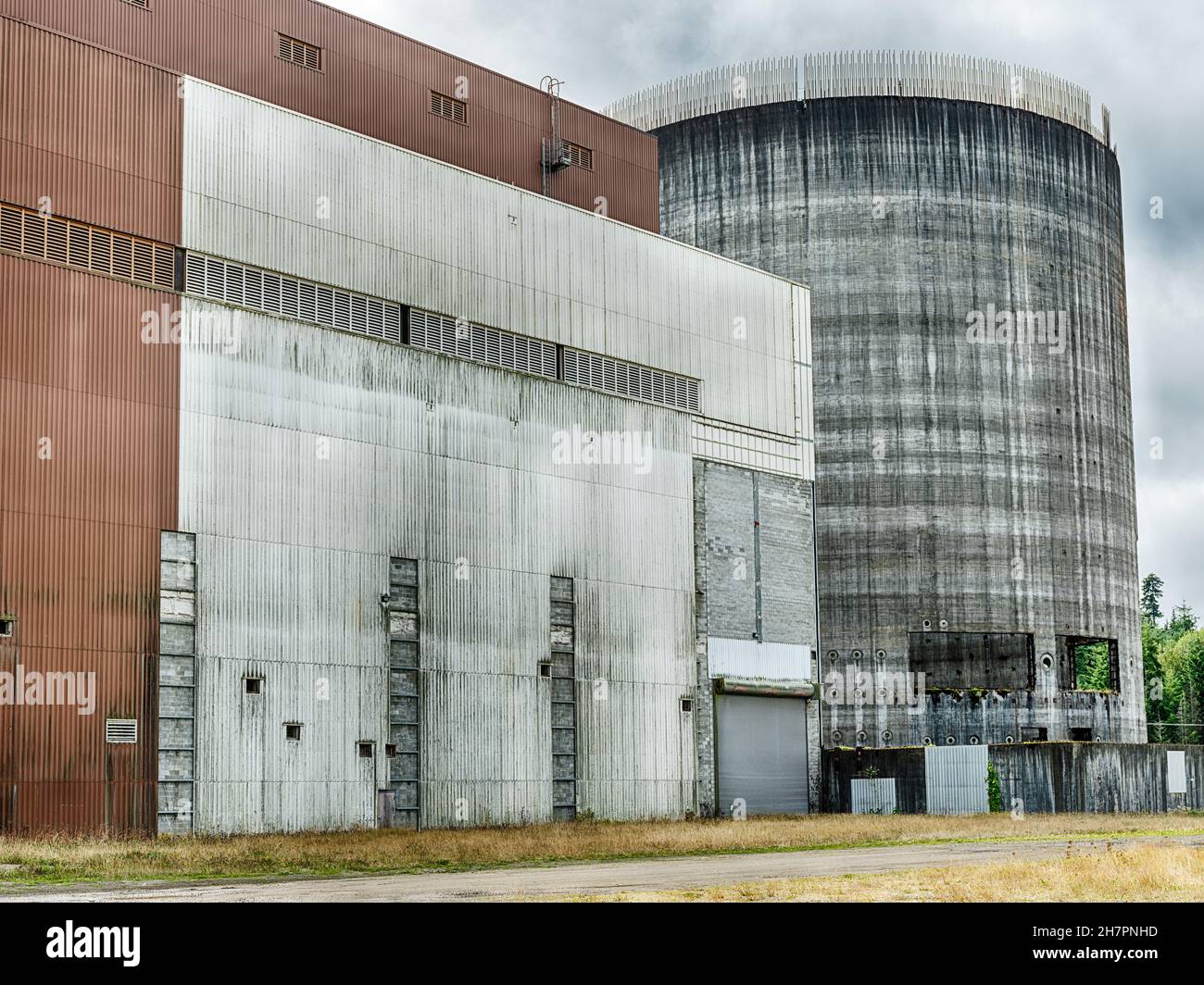 Ein unvollendeter Rückhalteturm neben dem Stromerzeugungsgebäude, von einer öffentlichen Straße aus gesehen. Stockfoto