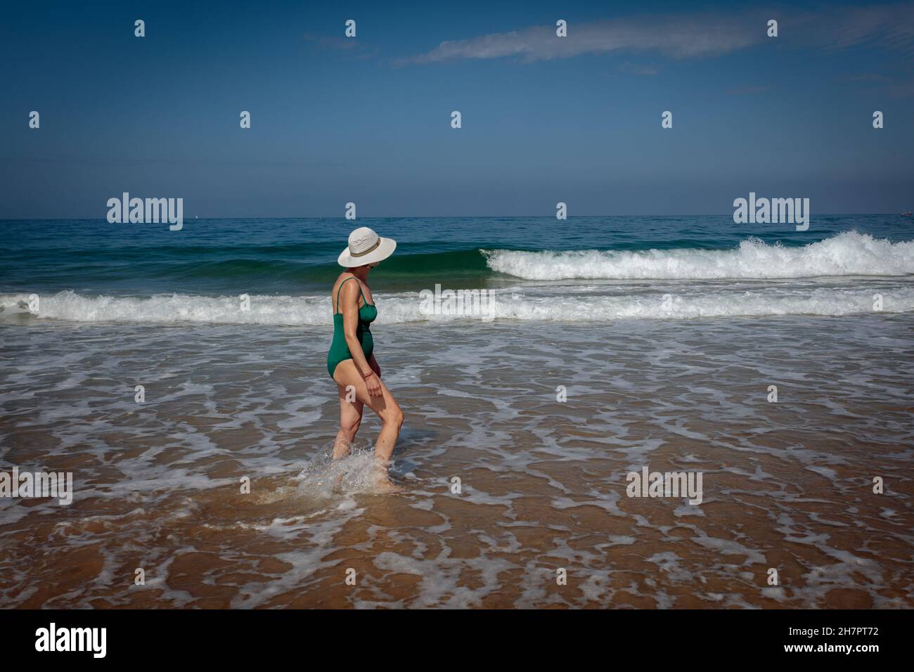 Frau, die am Strand in Hossegor, Landes, spazieren geht, sehr beliebt bei Surfern wegen der großen Wellen. Frankreich. Stockfoto