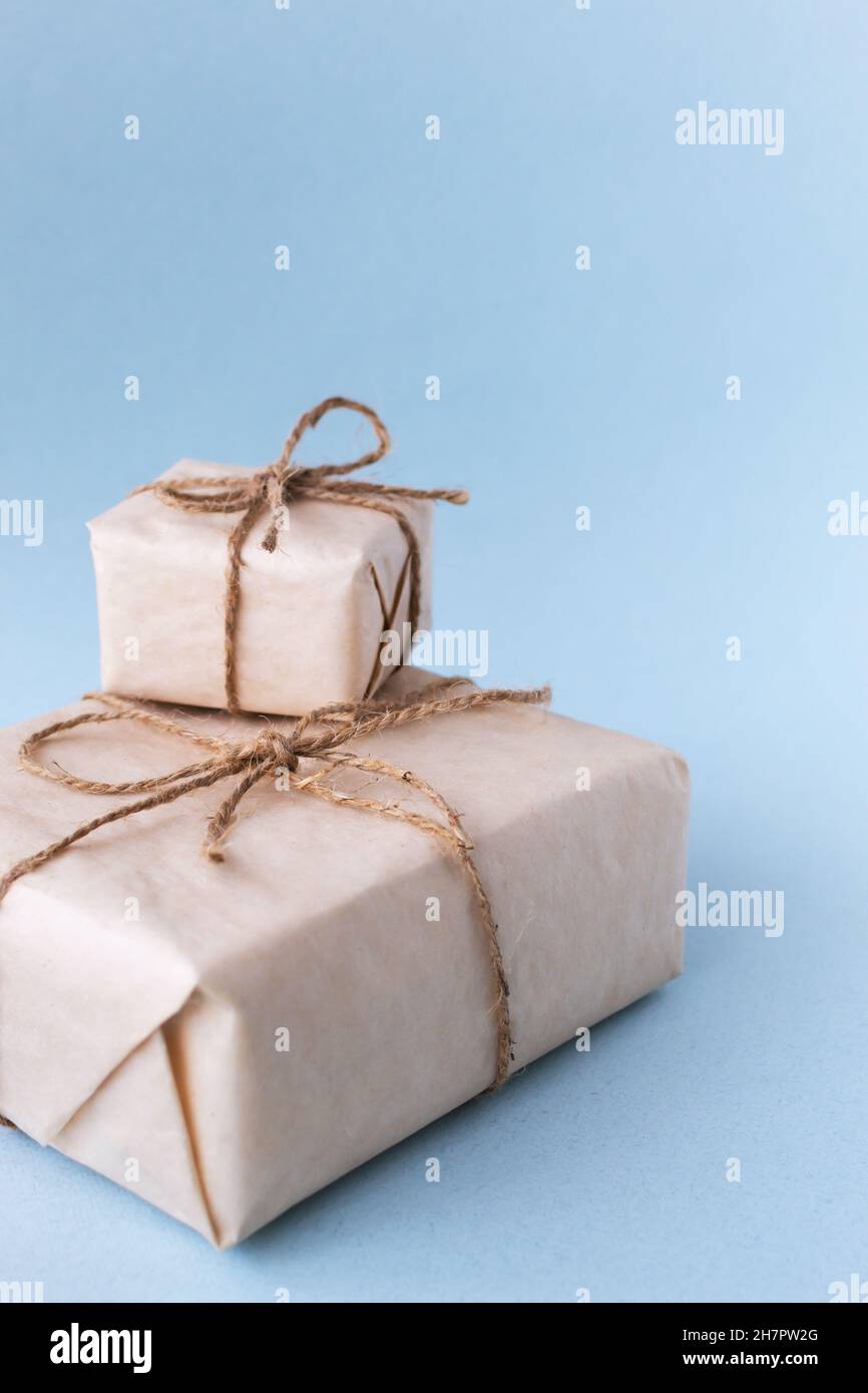 Braune Geschenkbox mit weißem Band auf klarem Hintergrund gebunden, Kopierraum, umweltfreundliches Geschenkkonzept Stockfoto