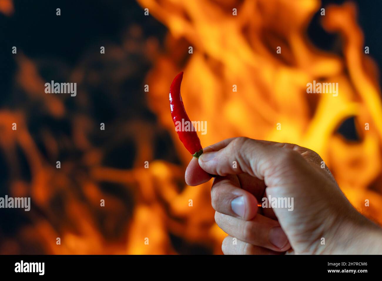 Chili Pfeffer würzig heiß auf Flammen Hintergrund Stockfoto