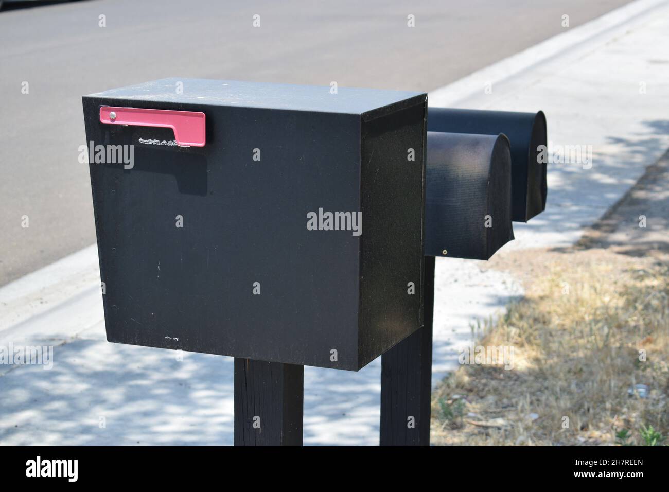 Winkelansicht der großen schwarzen ländlichen Mailbox von hinten. Stockfoto