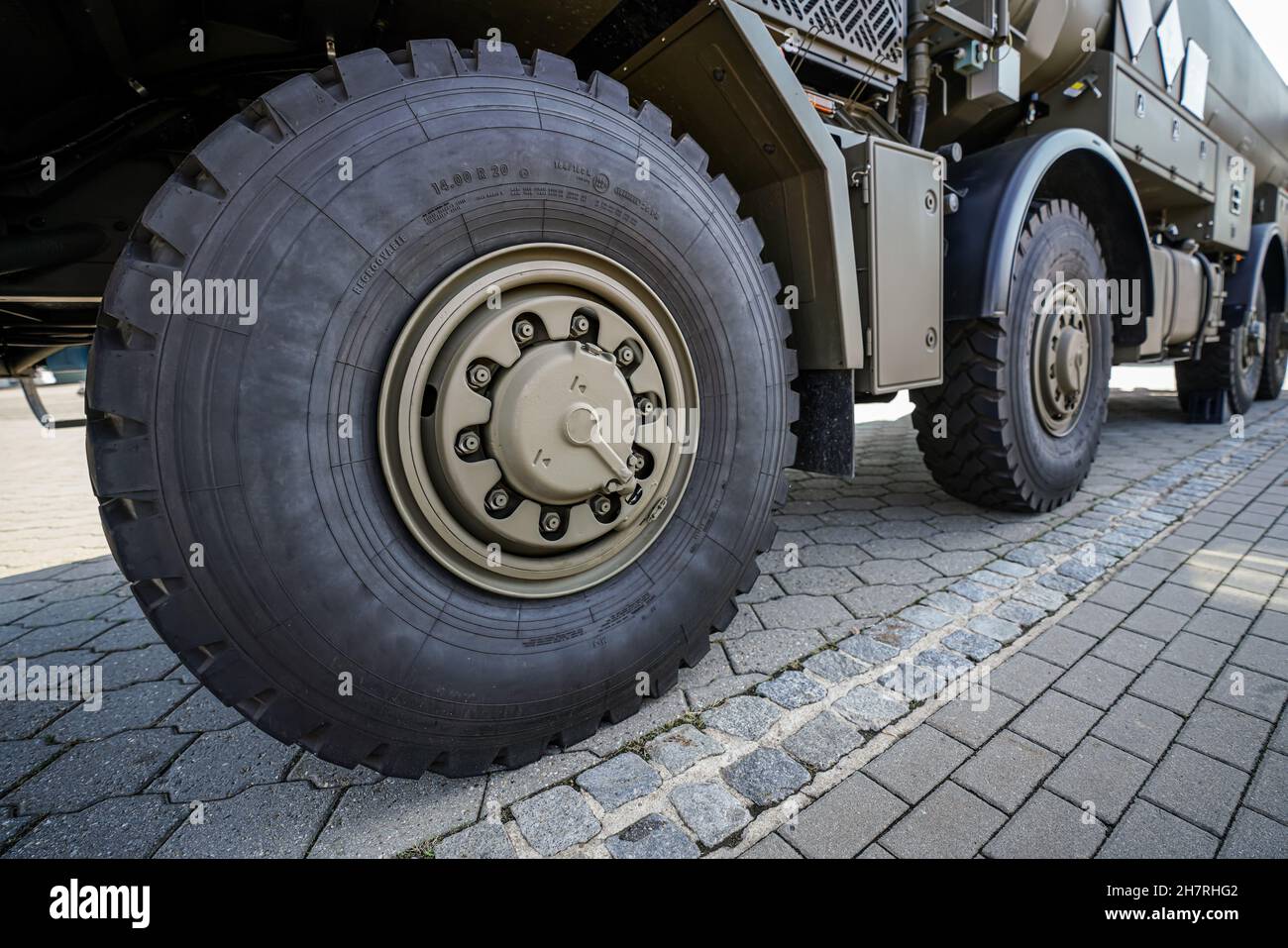 Große militärische Reifen auf grün-grauem Armeefahrzeug, Nahaufnahme Detail Stockfoto