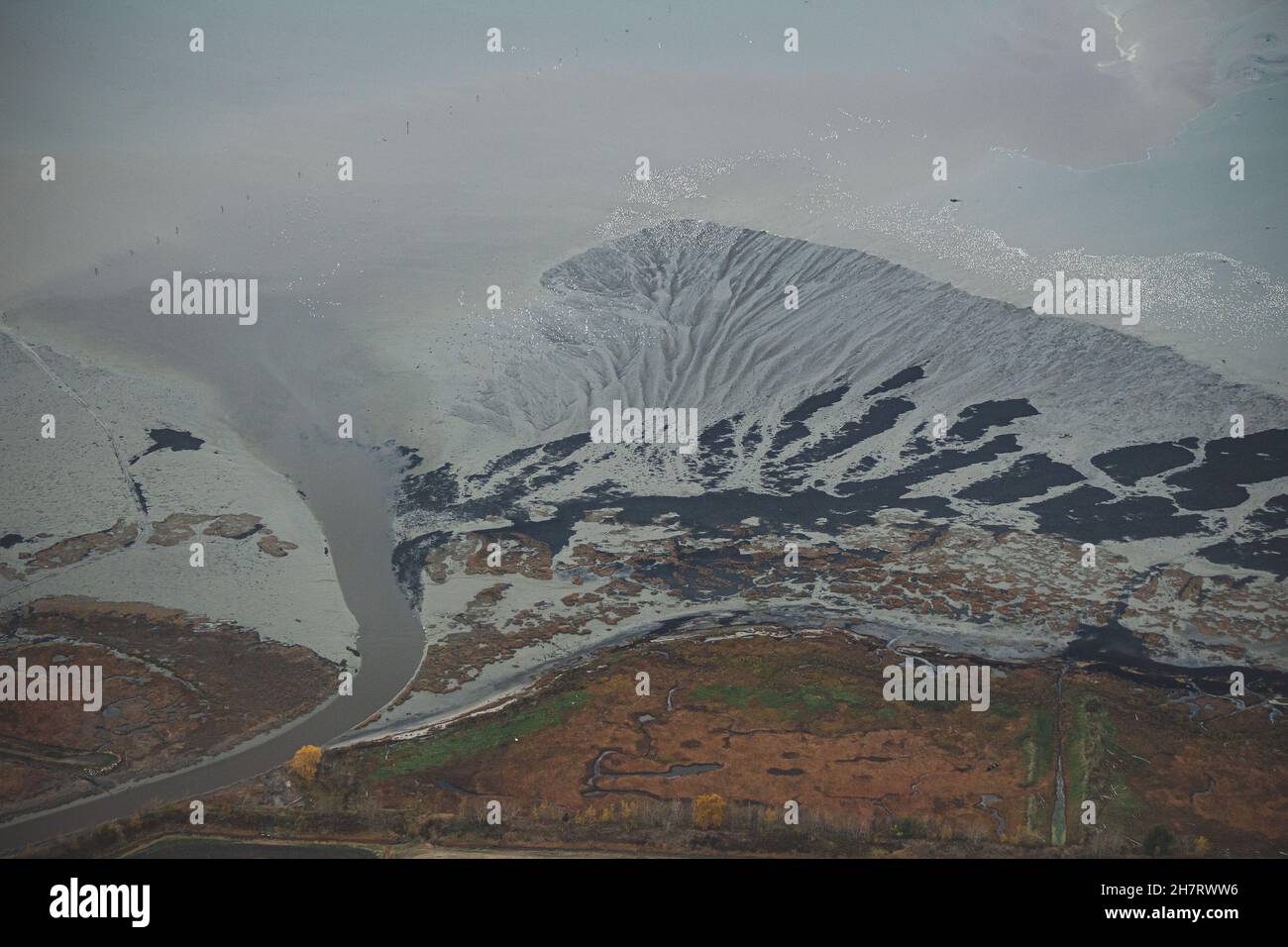 Die Landschaft der Straße auf den vom Schnee bedeckten Hügeln an einem düsteren Tag in Kamouraska, Quebec, Kanada Stockfoto