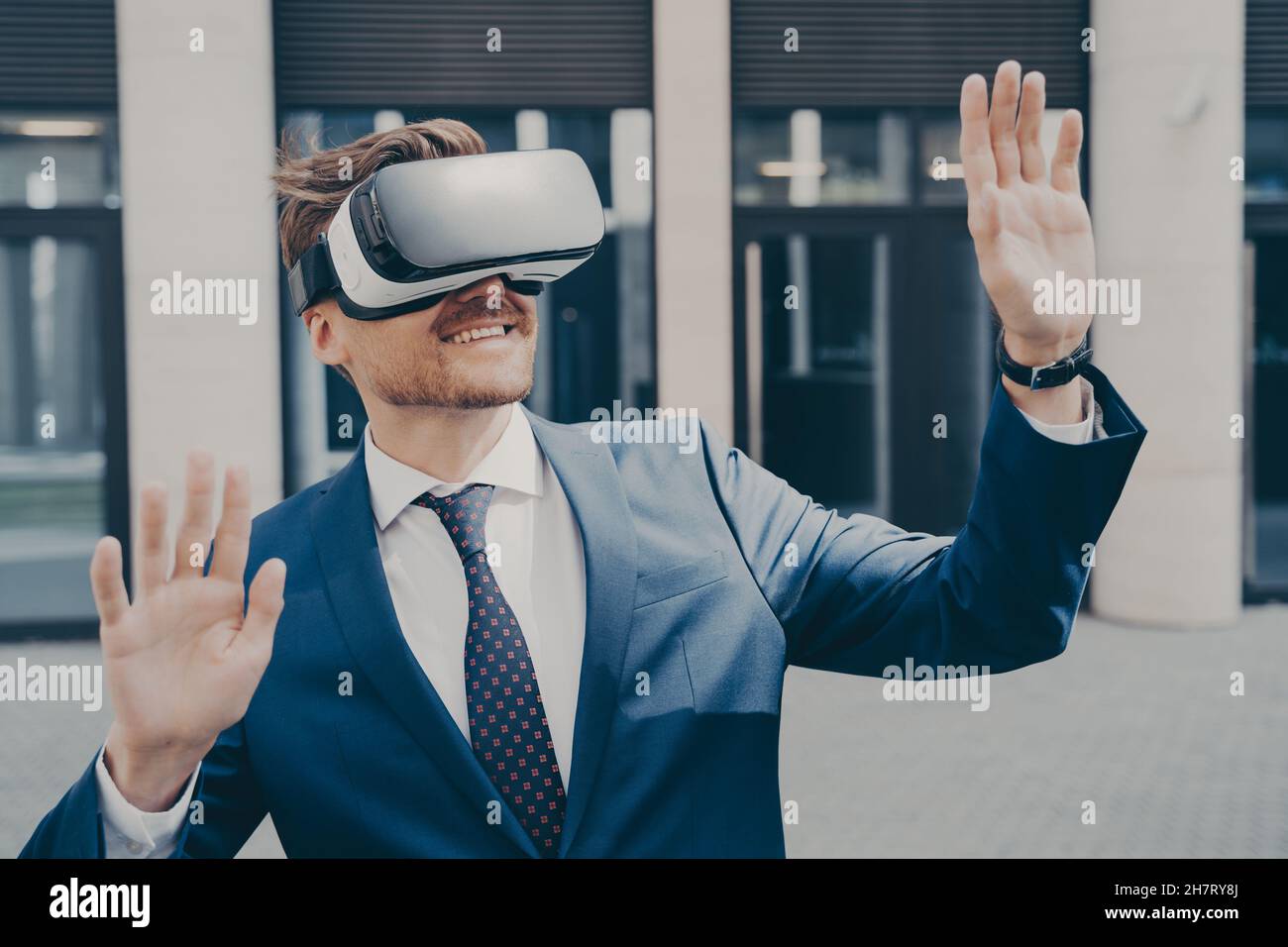 Erfolgreicher Videospielverlag mit schwarz-weißem VR-Headset, während er draußen steht Stockfoto