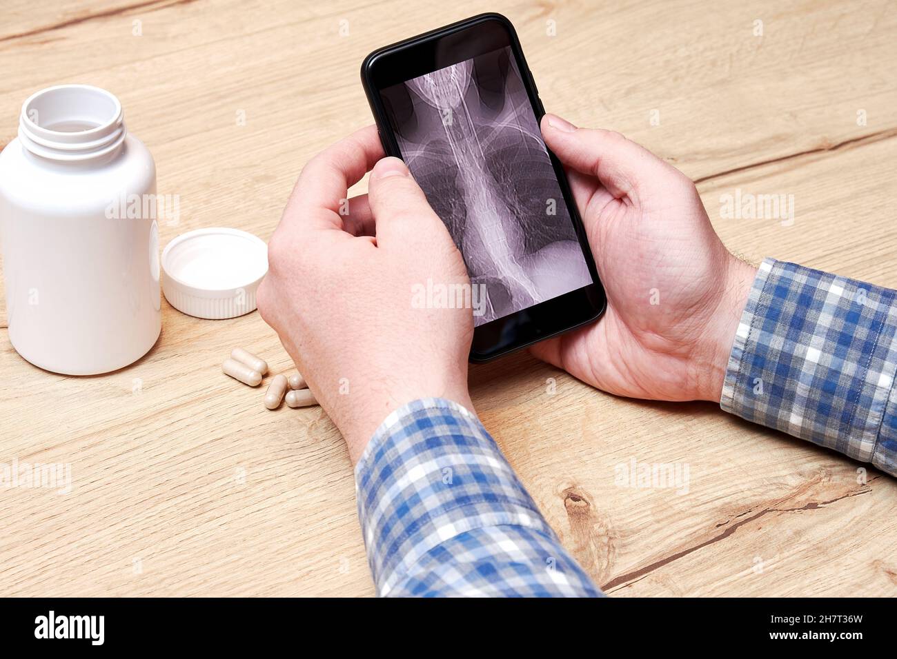 Mann, der zu Hause einen digitalen CT-Scan seiner Lunge analysiert. Lungenentzündung und Krankheitsdiagnose. Pillen und medizinische Flaschen Stockfoto