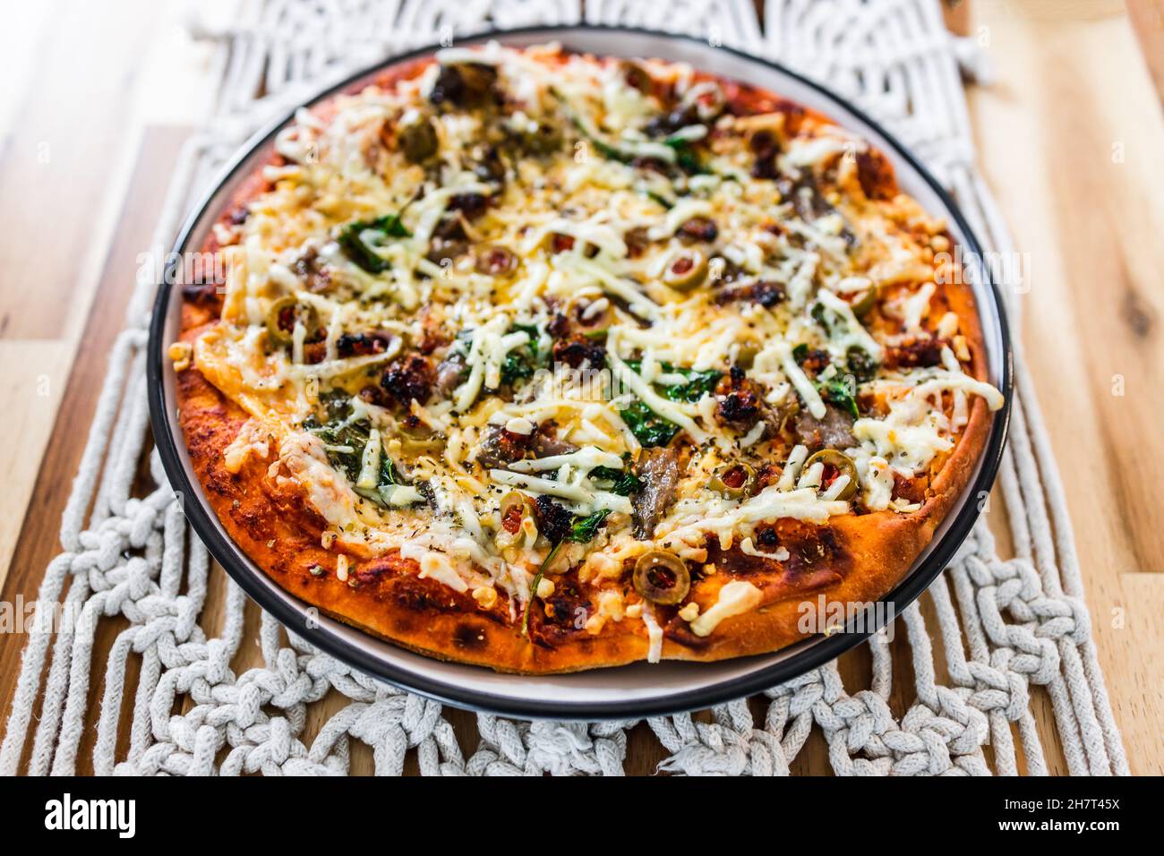 Vegane Pizza mit milchfreien Käsesoliven gerösteter Knoblauch und Spinat, gesunde pflanzliche Speiserezepte Stockfoto