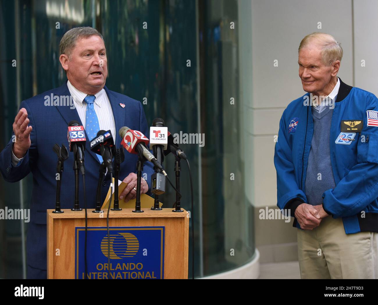 Phil Brown, CEO der Orlando Aviation Authority (L), hält seine Rede, während NASA-Administrator Bill Nelson (R) während einer Pressekonferenz zur Implementierung einer von der NASA entwickelten Flugplanungstechnologie für alle Flughäfen im ganzen Land im Jahr 2023 aufmerksam zuhört.das Luftraum-Technologie-Demonstrationssystem 2 (ATD-2) wurde übertragen An die Federal Aviation Administration (FAA) im September. Diese Technologie wird es den Flugzeugen ermöglichen, direkt zum Start auf die Startbahn zu Rollen, um übermäßige Ausfahrzeiten und Wartezeiten zu vermeiden und so den Kraftstoffverbrauch, die Emissionen und die Verspätungen der Passagiere zu reduzieren. Stockfoto