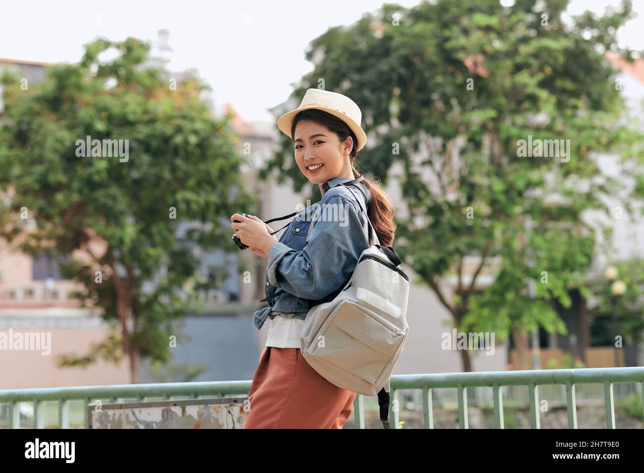 Asiatische Frau mit Fotokamera und Rucksack in der Stadt Stockfoto