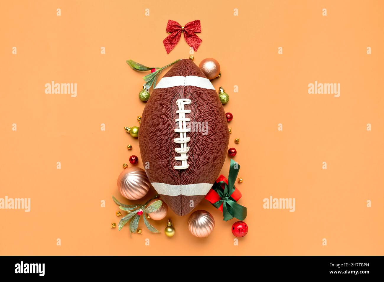 Weihnachtsbaum aus Rugby-Ball und Dekor auf farbigem Hintergrund Stockfoto