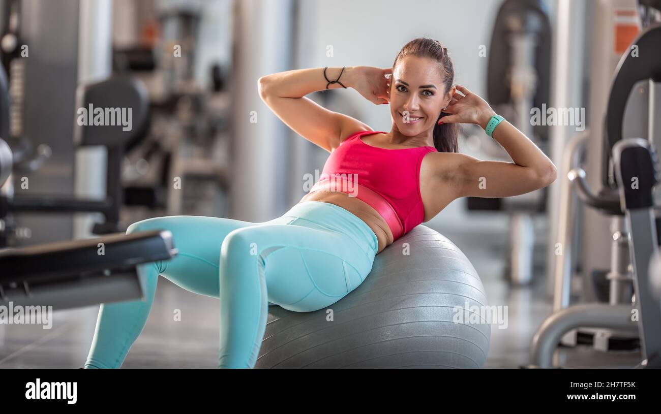 Fit Frau trainieren im Fitnessstudio tun knirscht auf einem Gymnastikball. Stockfoto