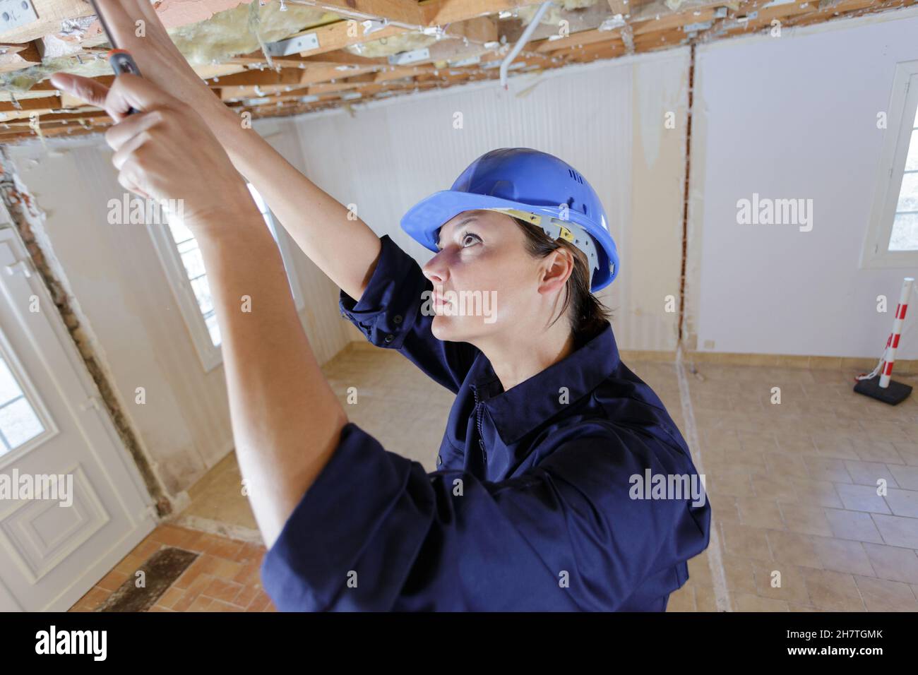 Weibliche Elektriker Verkabelung im Inneren Decke Stockfoto