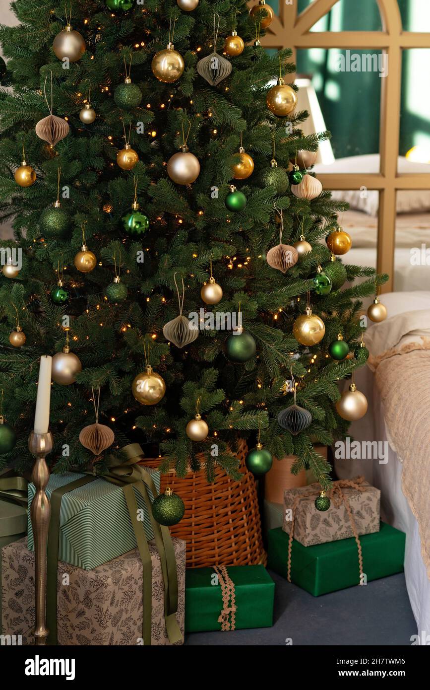 Hintergrund zum neuen Jahr. Weihnachtliche Einrichtung im Loft-Zimmer. Beleuchtung, großer Kristallleuchter, Kerzen und heiße Innenbeleuchtung, Girlanden. Weihnachtsbaum. Weich Stockfoto