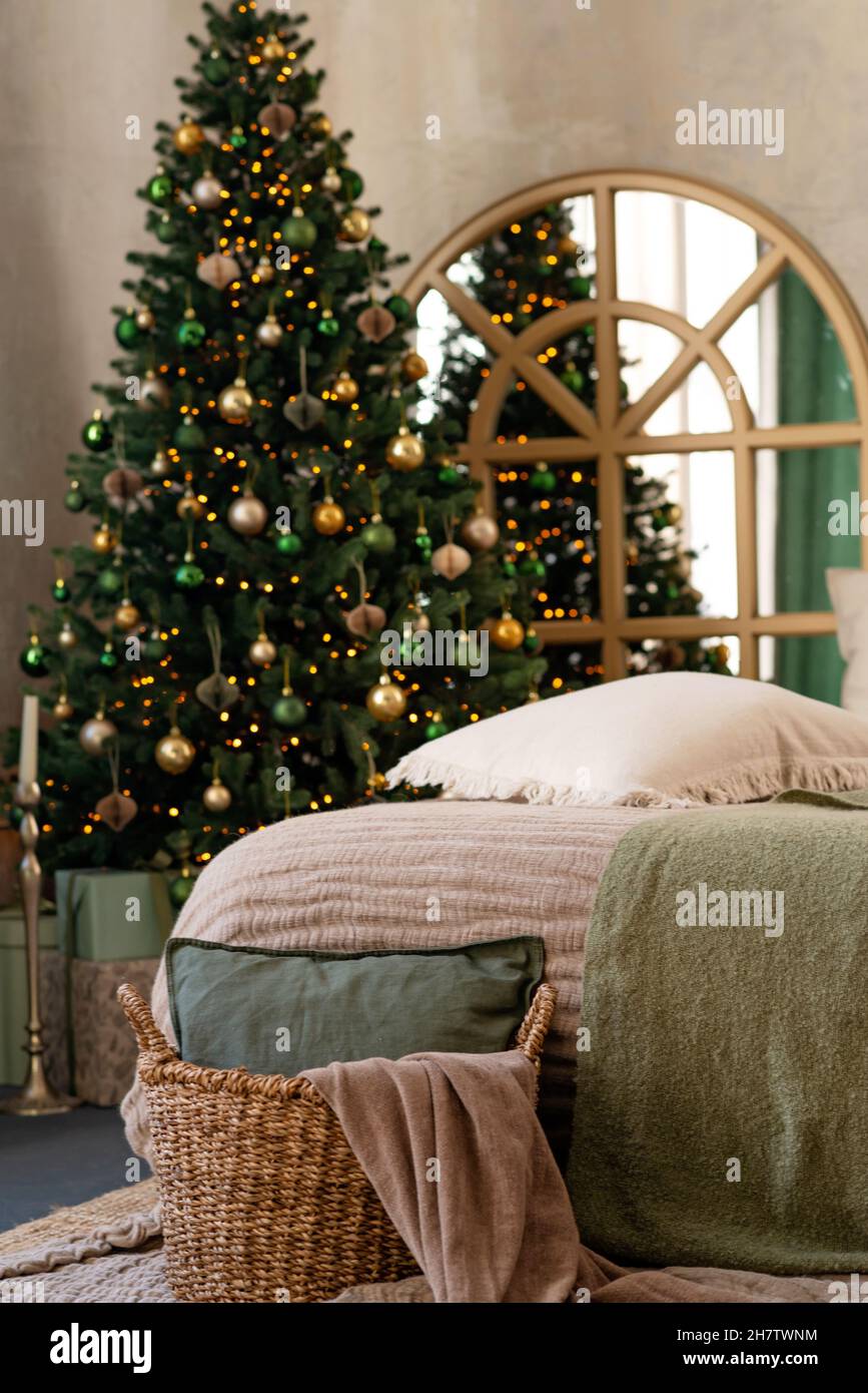 Hintergrund zum neuen Jahr. Weihnachtliche Einrichtung im Loft-Zimmer. Beleuchtung, Geschenke, Kerzen und heiße Innenbeleuchtung. Weihnachtsbäume mit Geschenken. Weicher, selektiver Fokus. Stockfoto