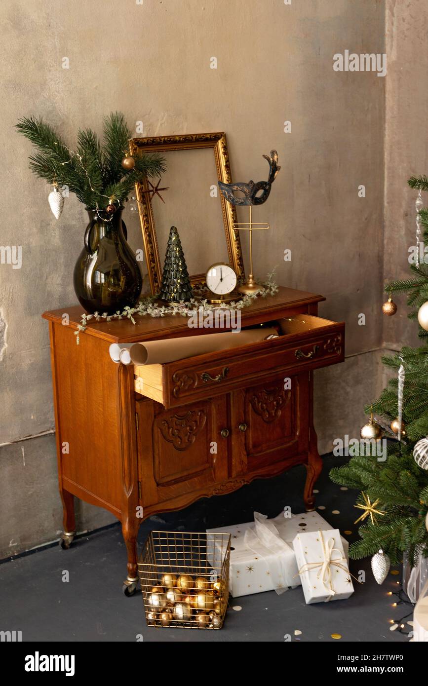 Hintergrund zum neuen Jahr. Weihnachtliche Einrichtung im Loft-Zimmer. Beleuchtung, antike Möbel, Kerzen und heiße Innenbeleuchtung, Girlanden in der Nähe des Weihnachtsbaums mit Stockfoto