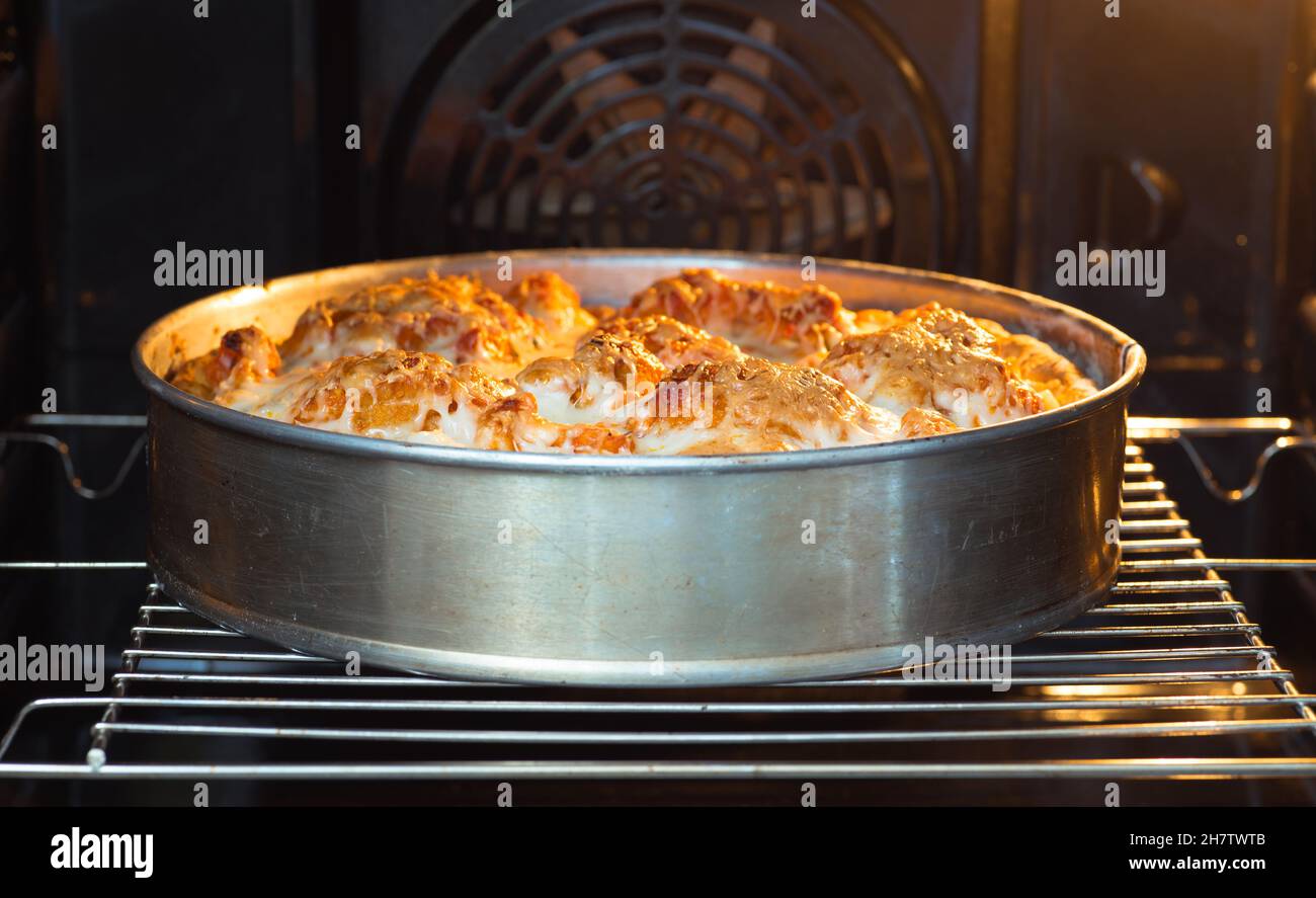 Fischkuchen mit Gemüse in Metallform mit einer goldenen Kruste auf dem Grill im Ofen. Hintergrund. Das Konzept, etwas zu backen. Stockfoto