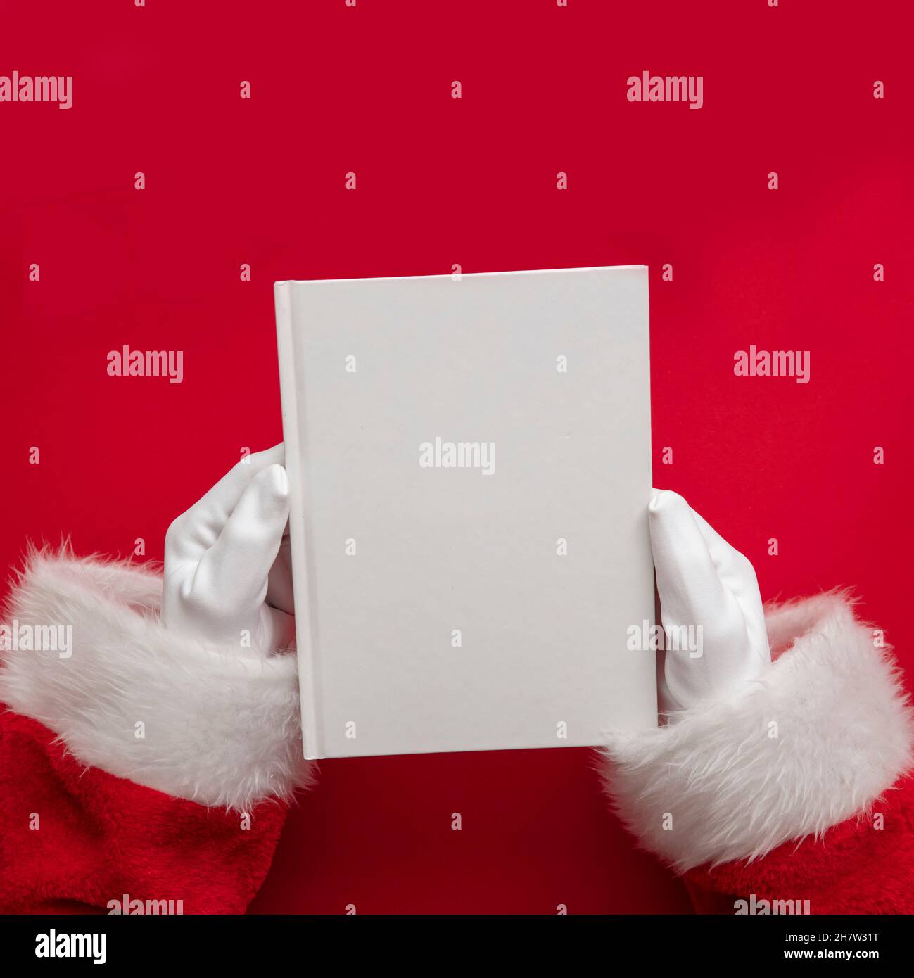 Der weihnachtsmann hält ein Buch mit leeren Seiten. Weihnachtsbuch-Mockup Stockfoto