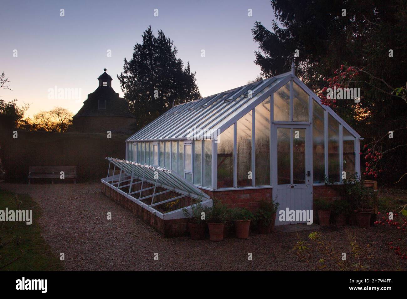 Gewächshaus und Taubenschlag am frühen Morgen im Rousham House & Gardens, Oxfordshire Stockfoto