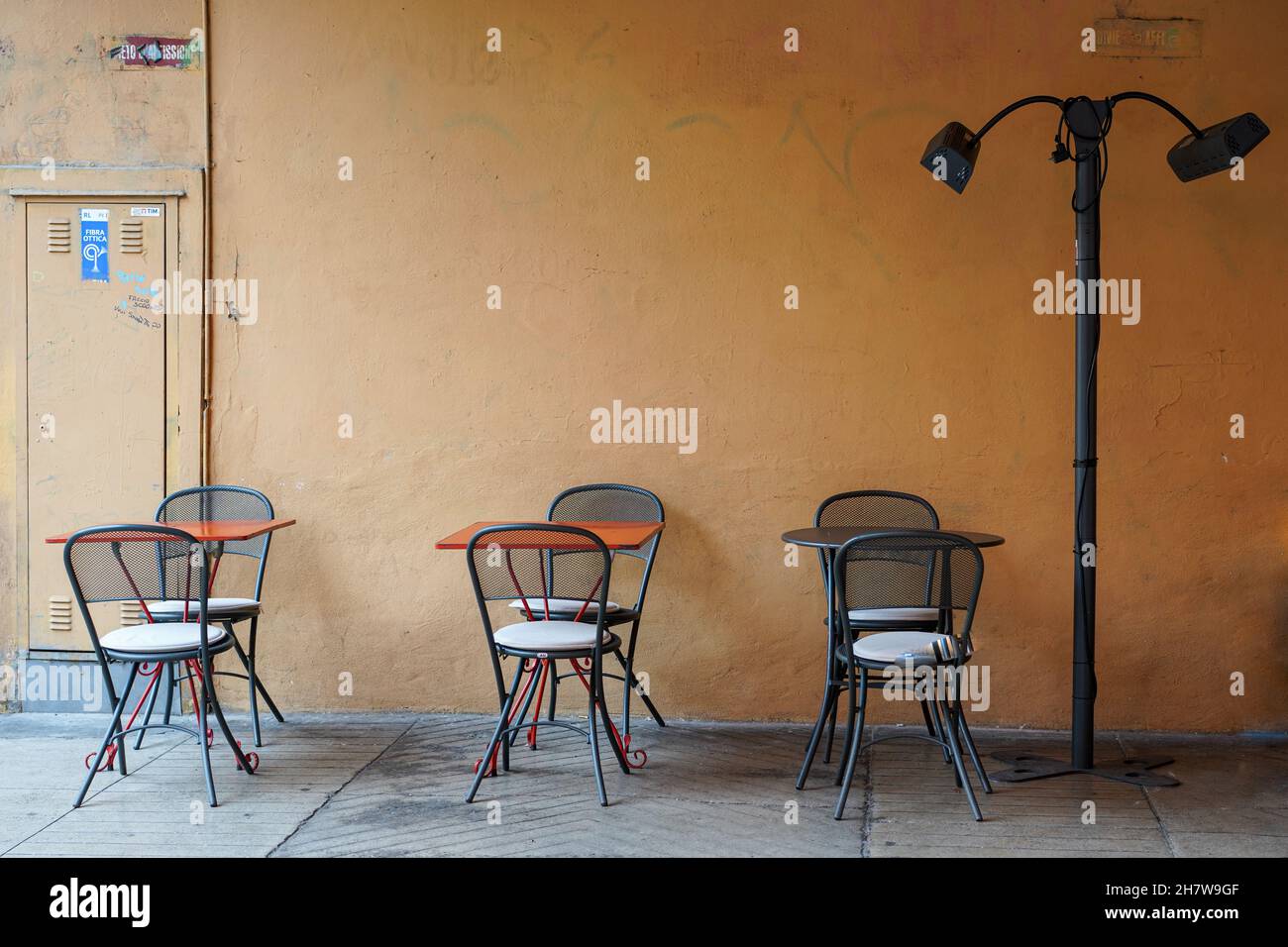 Restaurant ohne Kunden in Bologna während der Corona-Pandemie. Leere Tische und Stühle auf dem Bürgersteig davor. Stockfoto