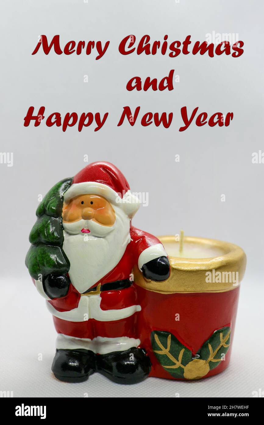 Weihnachtsmann mit rotem Körper, grüner Weihnachtsbaum und Kerze, Weihnachtsmann Keramikfigur auf weißem Hintergrund, Weihnachtsdekoration, Neujahrskarte, Stockfoto