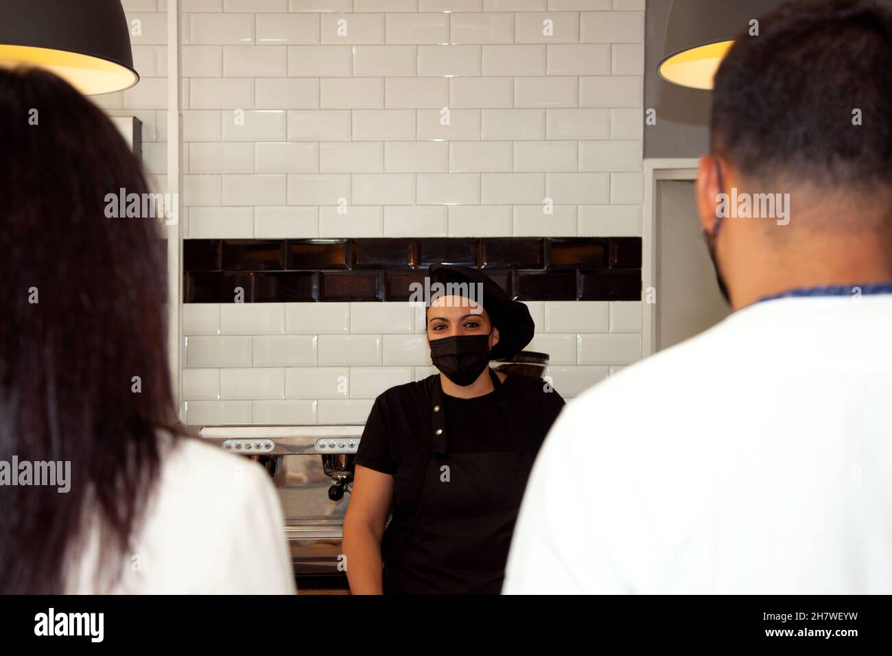 Paar bestellen im Café. Mitarbeiter im Café, der die Öffentlichkeit bedient. Kundensupport. Kunden, die im Café bestellen. Stockfoto