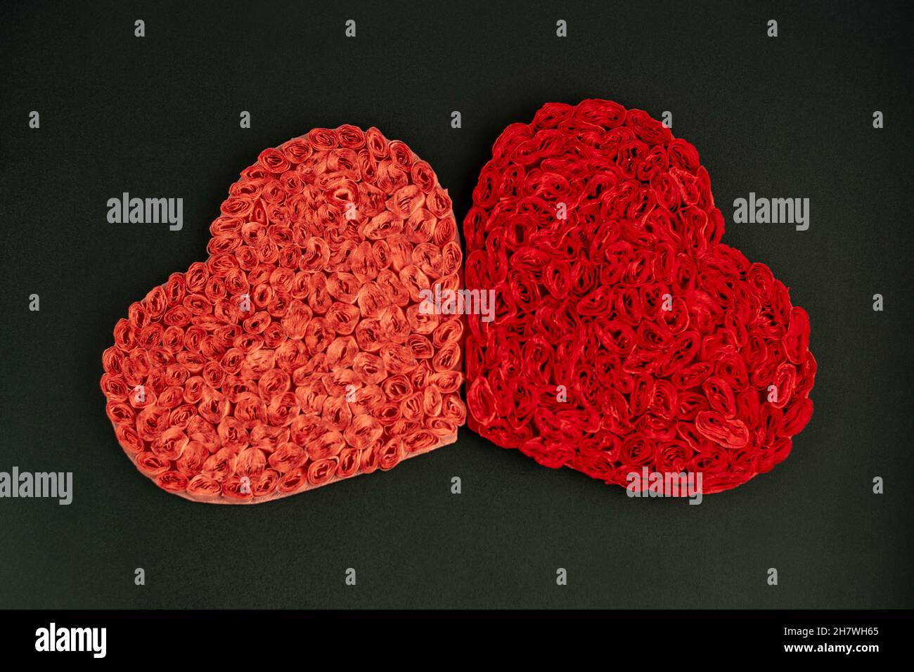 Zwei Herzen auf dunklem Hintergrund zur Dekoration zum Valentinstag, zur Hochzeit. Stockfoto