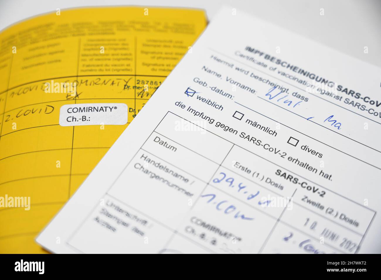 Gelbes internationales Impfzeugnis und deutsche Rekordkarte für die Impfung gegen SARS-CoV-2 Covid-19, Konzept für Reiseanforderungen duri Stockfoto
