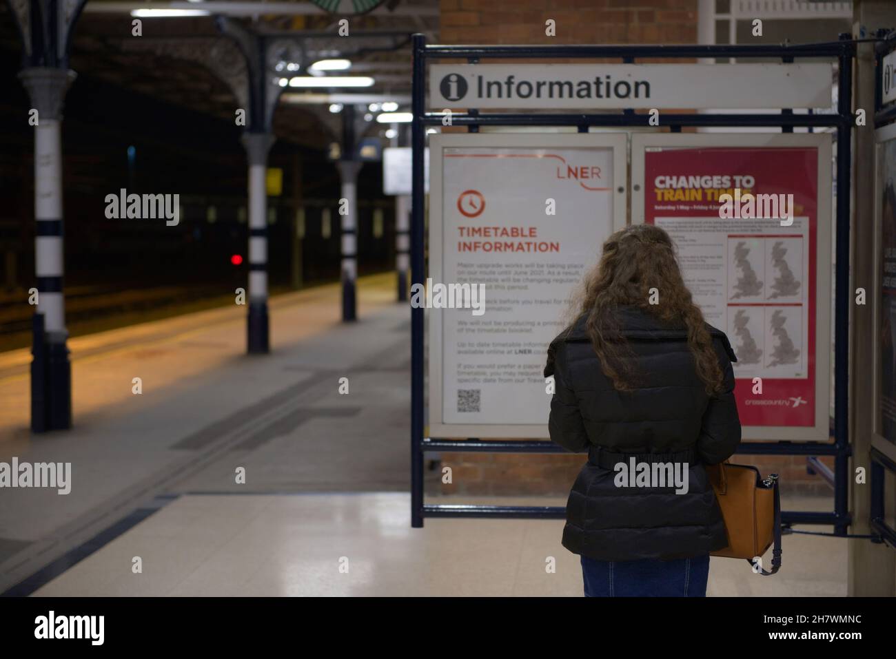 Doncaster, Großbritannien, 22nd. Mai 2021: Nahaufnahme einer jungen Frau, die nachts die Informationstafel des Bahnhofs von doncaster las. Plattformhintergrund Stockfoto