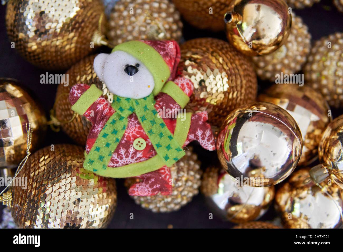 Schneemann und Weihnachtsschmuck auf glänzenden goldenen Kugeln im Hintergrund. Frohe weihnachten. Horizontal. Platz kopieren. Frohes neues Jahr. Lustige festliche Chara Stockfoto