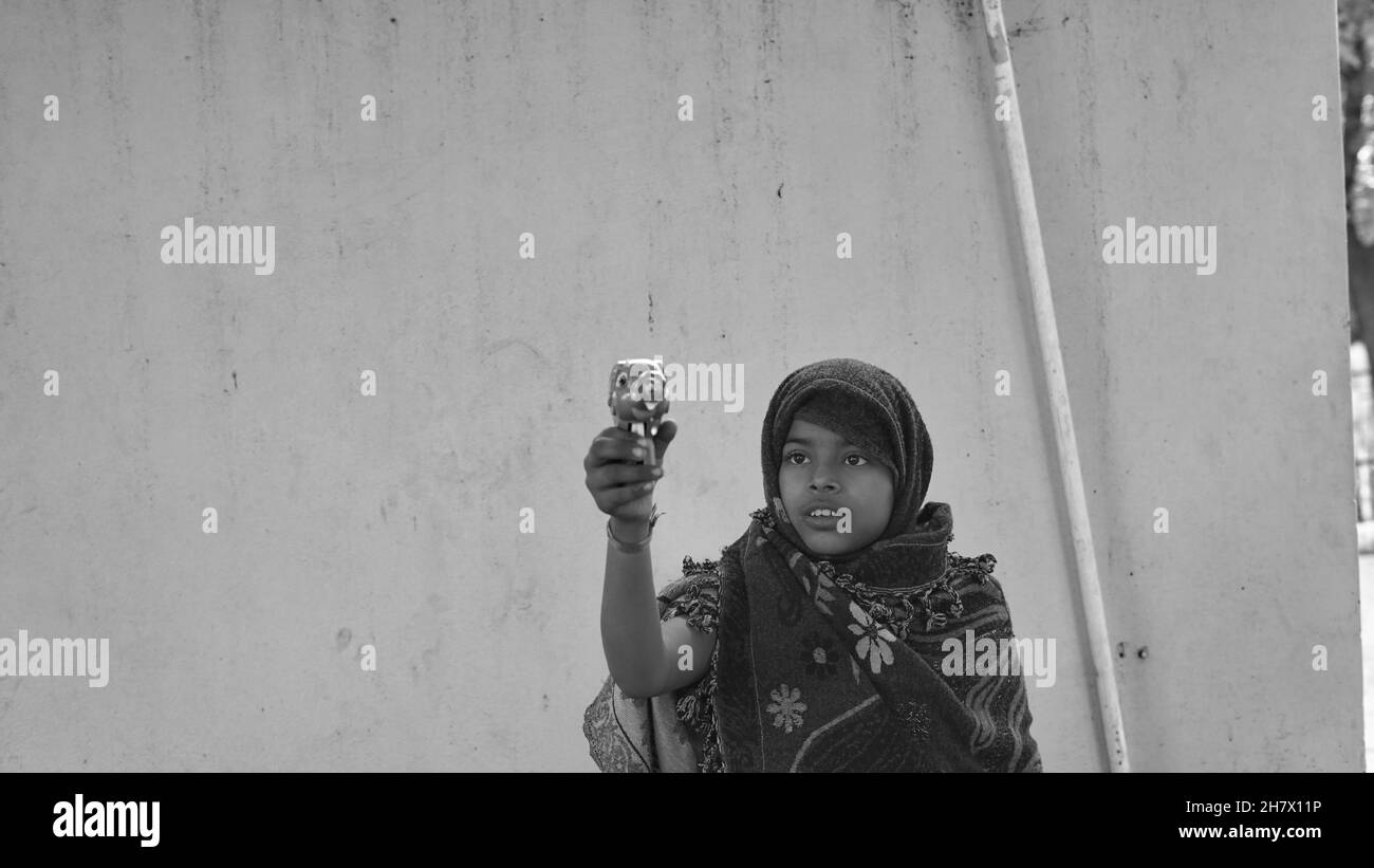 Schwarz-weiß Schuss, glücklich asiatische kleine Mädchen blasen Blasen mit einem Spielzeug Pistole an einem Sommertag. Stockfoto