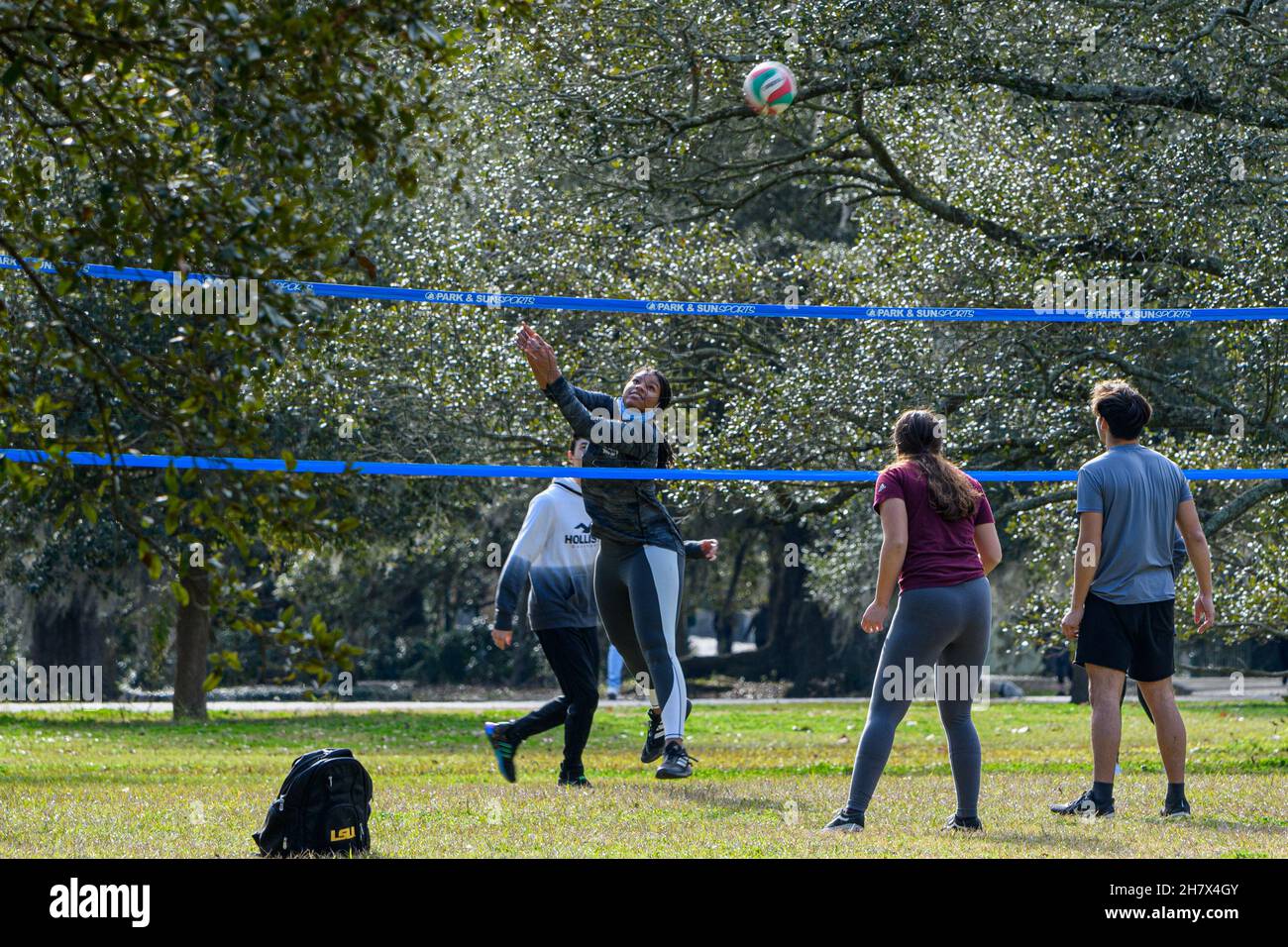 NEW ORLEANS, LA, USA - 2. JANUAR 2021: Pickup-Volleyballspiel mit weiblicher Setterin und Ball in Bewegung, im Audubon Park Stockfoto
