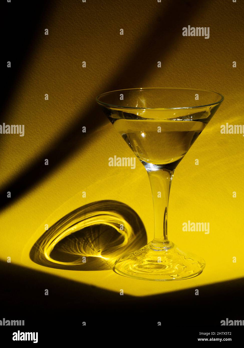 Ein Glas auf gelber Oberfläche Stockfoto