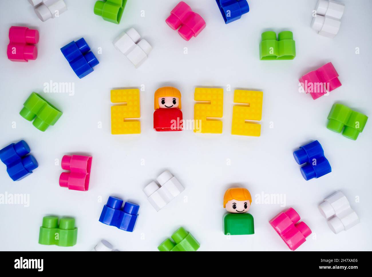 Retro bunte Bausteine, Spielzeug Kunststoff-Figuren: Mädchen in 2022 Zahlen und grünen Jungen auf weißem Hintergrund. Stockfoto