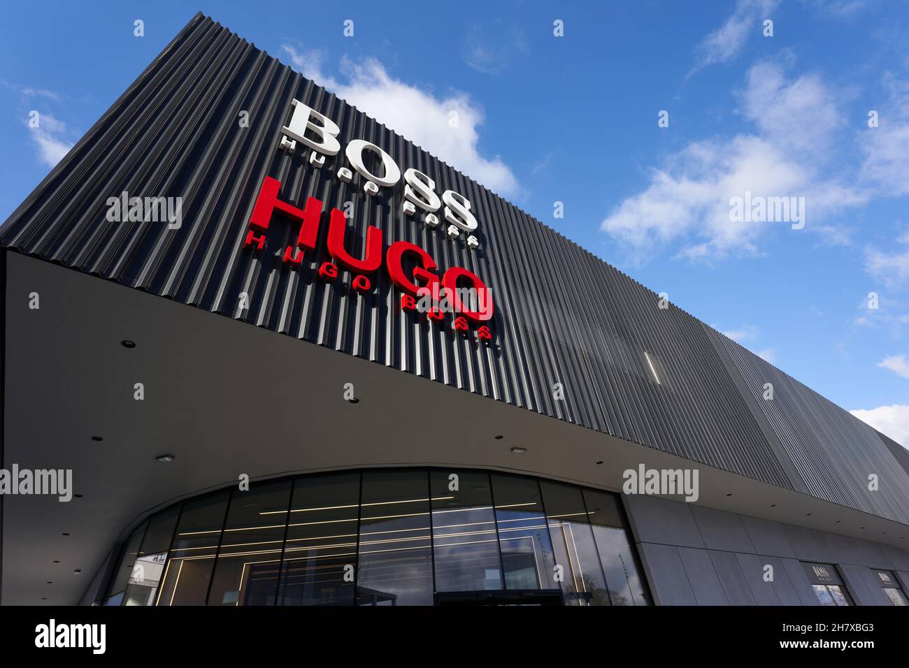 Metzingen, 20. März 2021: Hugo Boss Outlet Store. Schwarze Außenfassade mit  Firmenlogo vor blauem Himmel. Ansicht von oben Stockfotografie - Alamy