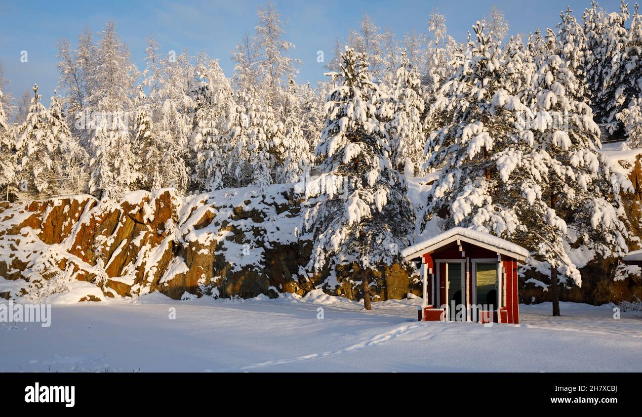 Leeres rotes Nebengebäude an der Rasthaltestelle Kukkokievari ( viitostie , Highway 5 , E63 ) an eiskaltem Wintertag, Finnland Stockfoto
