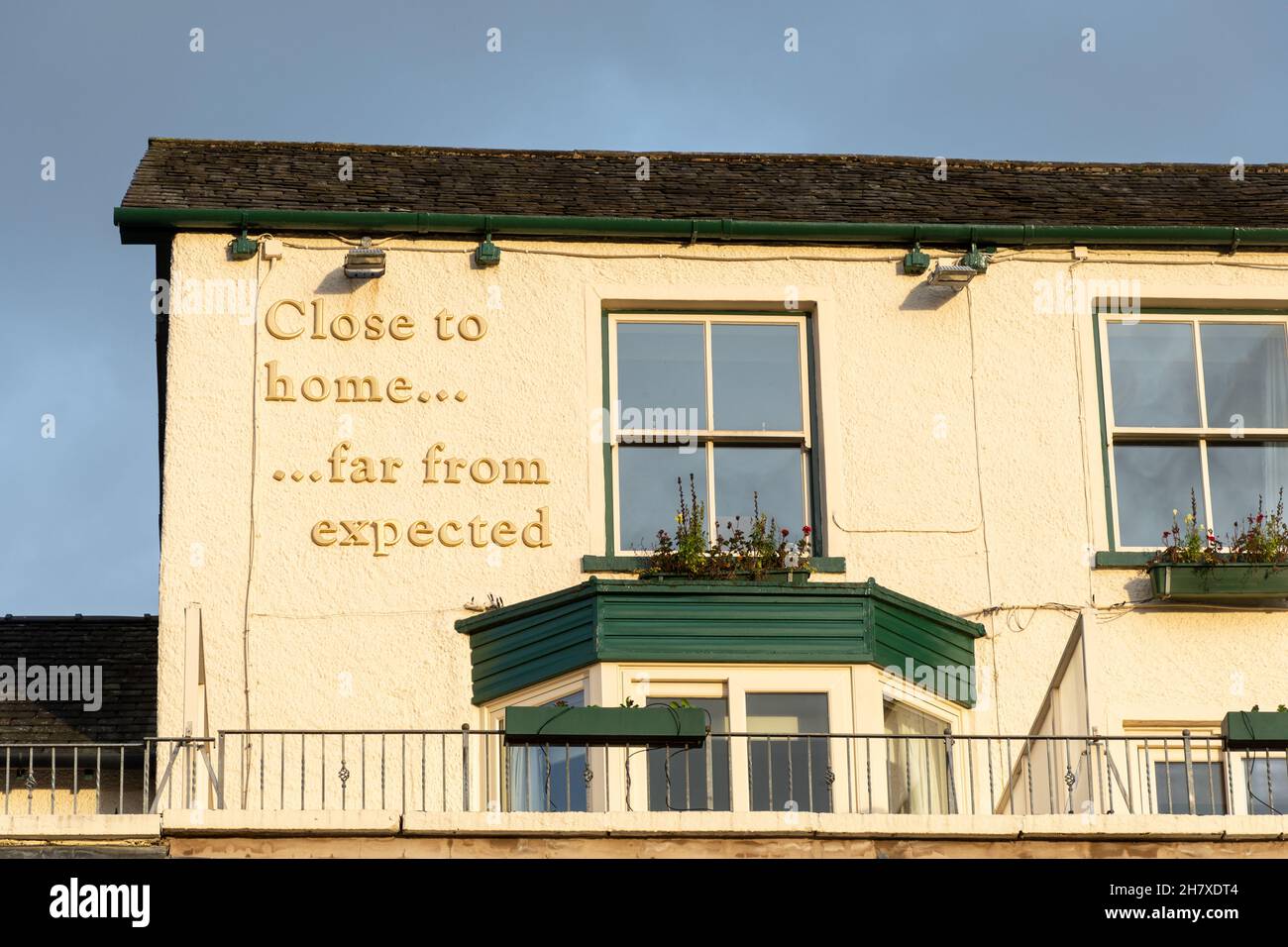 Ambleside Salutation Health Club and Spa, „Close to Home... far from expected“, Worte an der Außenwand des Hotels, Lake District, Cumbria, Großbritannien Stockfoto