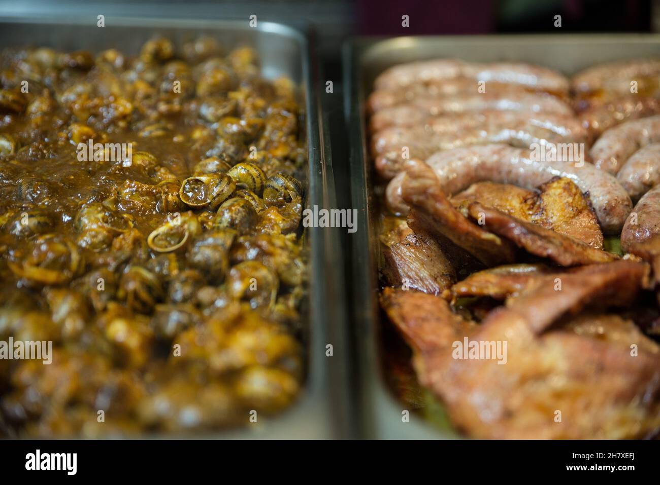 Präsentation eines Essens zum Mitnehmen mit zwei Tabletts mit verschiedenen Fleischsorten und Schnecken Stockfoto