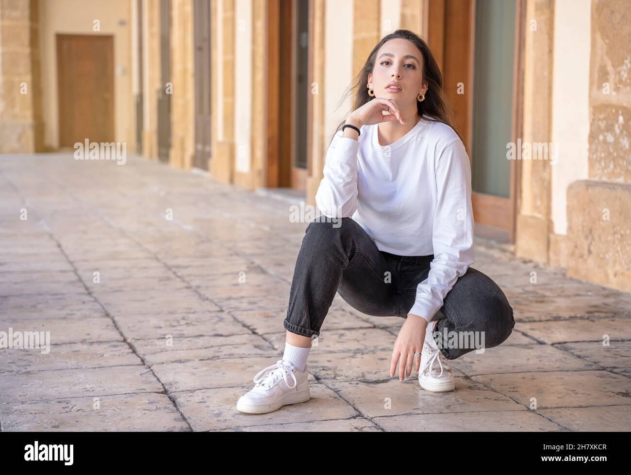 Porträt des jungen schönen kaukasischen braune Haare Frau posiert im Freien in der Stadt, Blick in die Kamera, nachdenklich - ernst, melancholisch, heiter Konzept Stockfoto