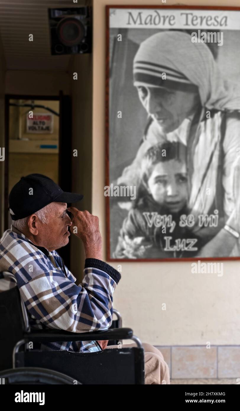 Patient im Altenheim in Costa Rica, der sich in der Nähe eines Bildes von Mutter Teresa ausruhen muss Stockfoto
