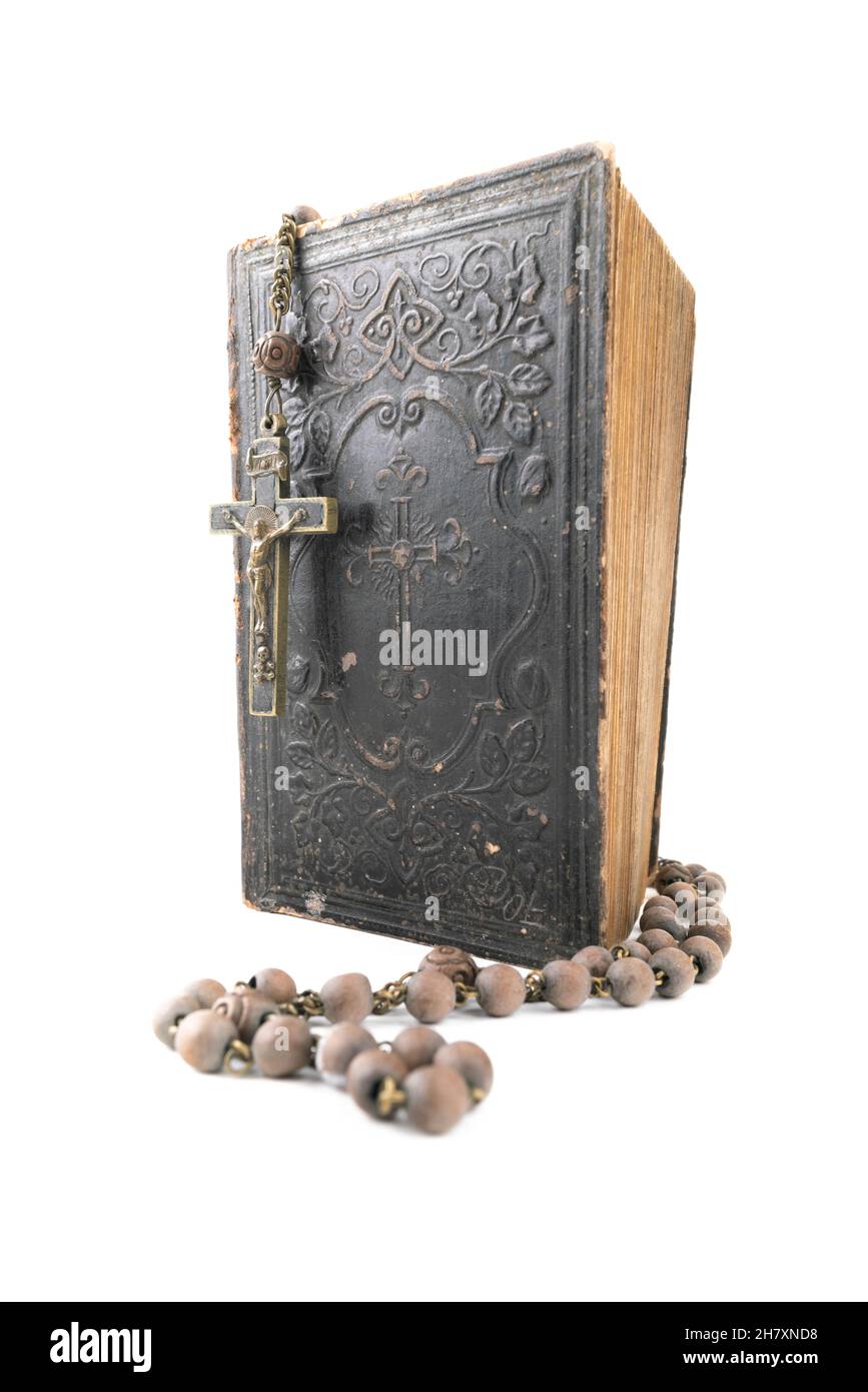 Große vertikale Studioaufnahme der sehr alten, alten Heiligen Bibel mit vielen Ornamenten auf dem Cover und gelben Seiten und altem Rosenkranz isoliert auf Weiß Stockfoto
