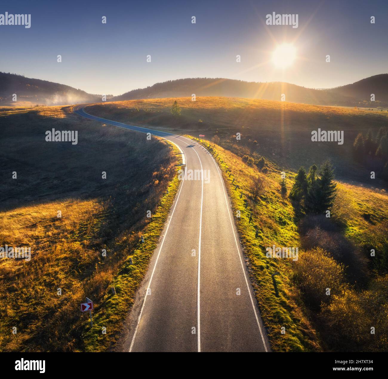 Luftaufnahme der Bergstraße im Wald bei Sonnenuntergang in Herbst Stockfoto