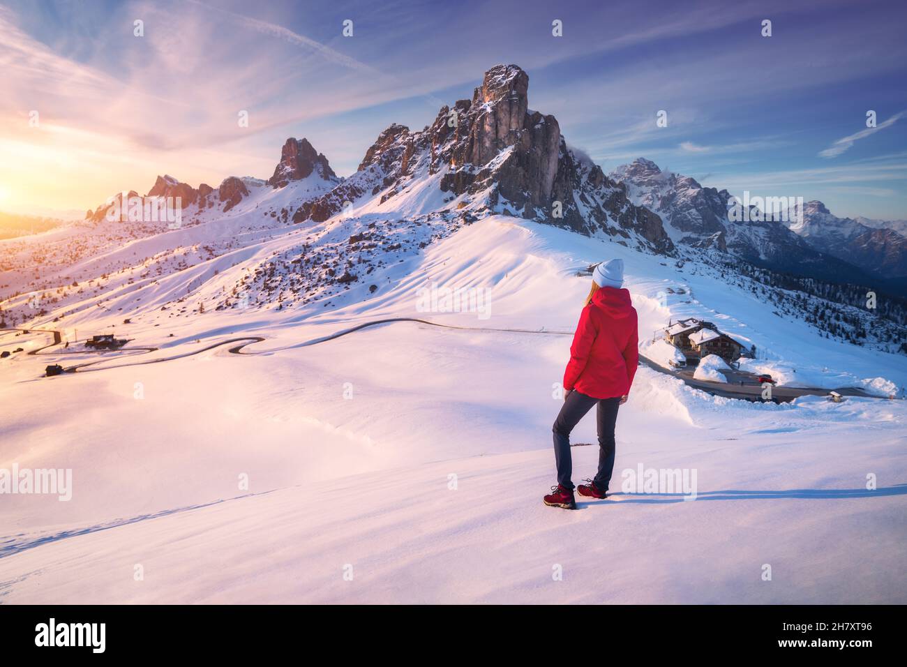 Junge Frau in verschneiten Bergen bei Sonnenuntergang im Winter. Landschaft Stockfoto