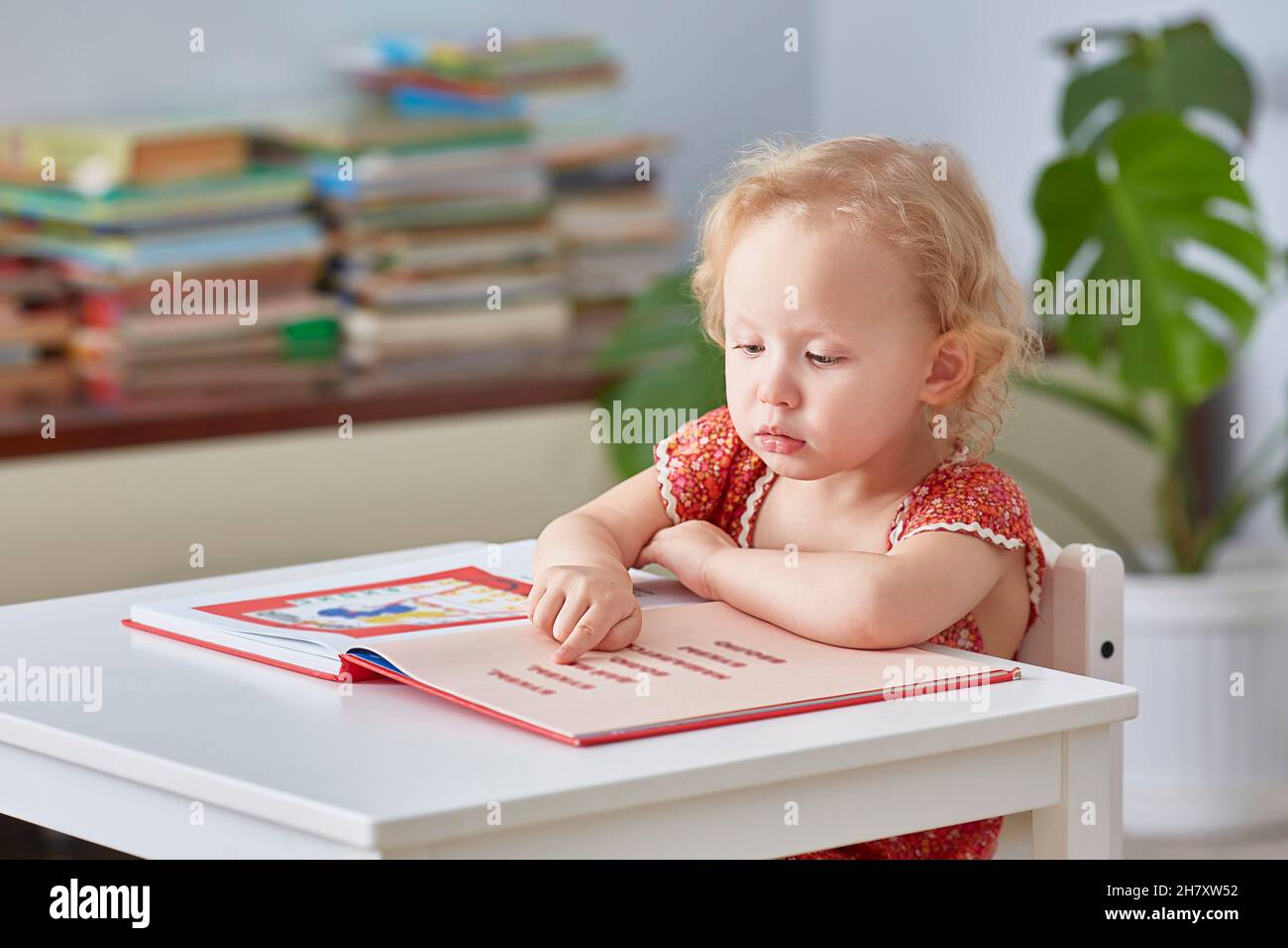 Mädchen interessiert Buch lesen Home Bibliothek. Konzept Unterricht Kinder. Lifestyle. Stockfoto