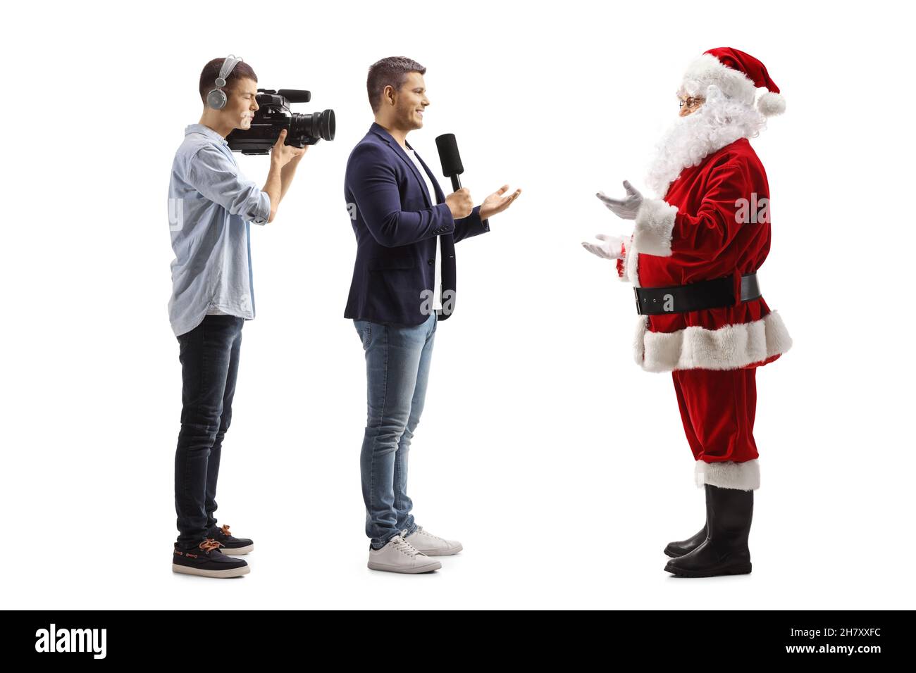 Ganzkörperaufnahme eines Reporters und eines Kameramanns, der den weihnachtsmann isoliert auf weißem Hintergrund interviewte Stockfoto