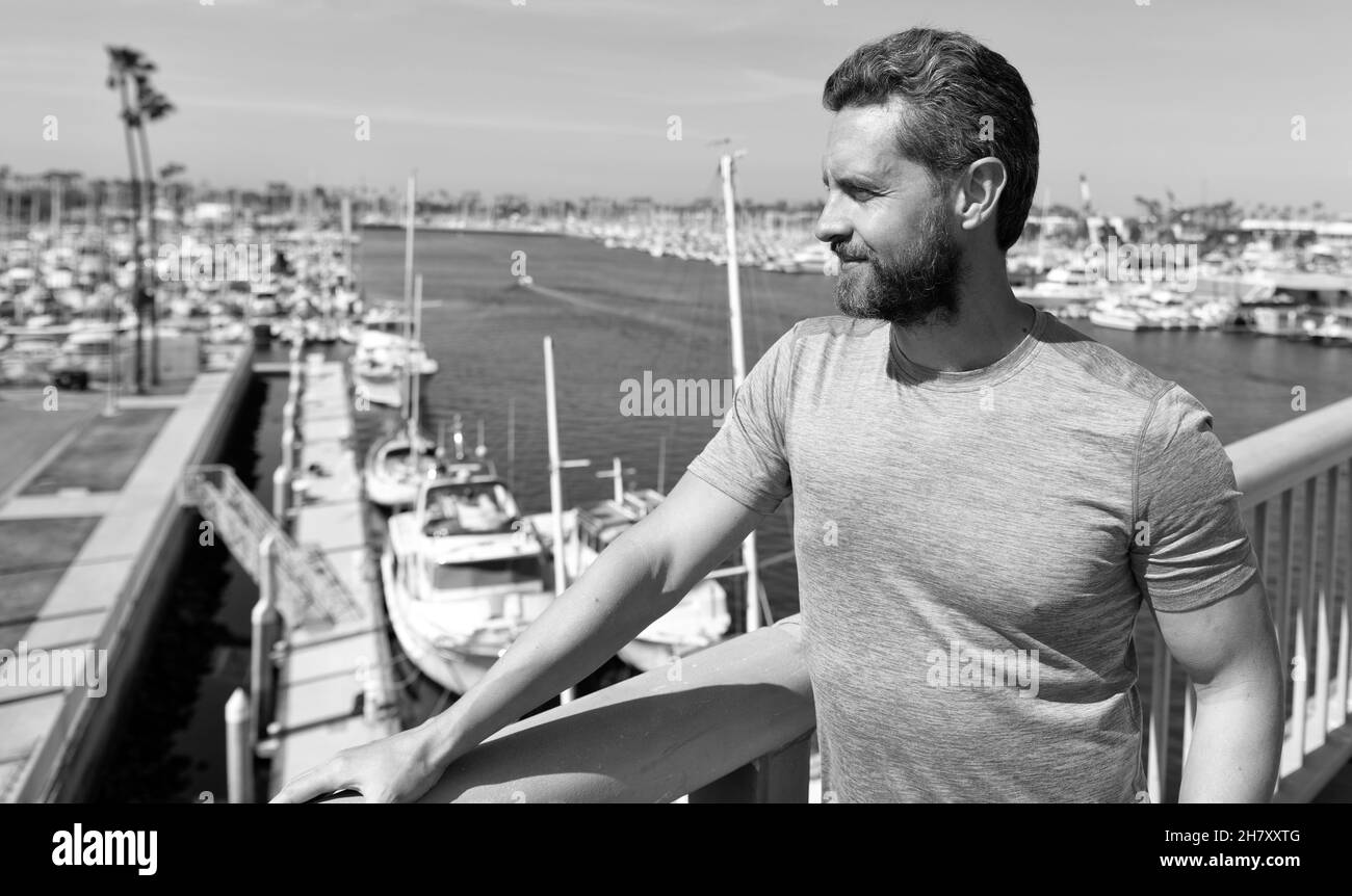 Schöner Mann Urlauber stehen an Brücke Geländer über Fluss Sommer im Freien, Urlaub Stockfoto