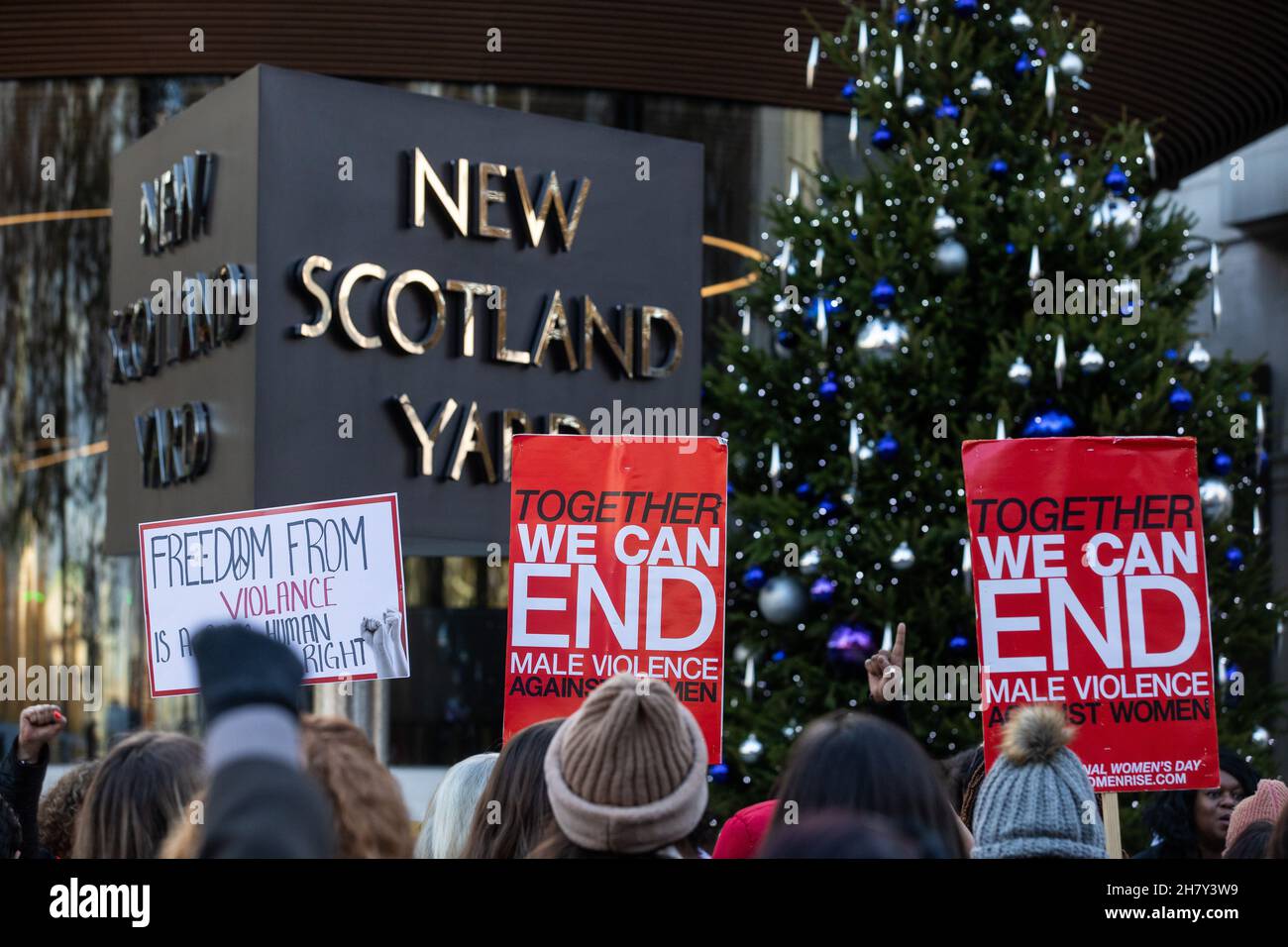 London, Großbritannien. 25th. November 2021. Dutzende von Unterstützern von Millionen Women Rise nehmen an einer Mahnwache vor dem New Scotland Yard Teil, um an die Opfer männlicher Gewalt gegen Frauen am Internationalen Tag zur Beseitigung von Gewalt gegen Frauen zu erinnern. Die Aktivisten sprachen von Sarah Everard, Nicole Smallman und Bibaa Henry, deren Bilder mit denen anderer Frauen in der Nähe des Hauptquartiers der Metropolitan Police positioniert wurden, und hoben die katastrophalen Versäumnisse von Polizeibeamten zum Schutz von Frauen und Mädchen vor Gewalt sowie rassistische Einstellungen unter Polizeibeamten hervor. Kredit: Mark Kerrison/Alamy Live Nachrichten Stockfoto