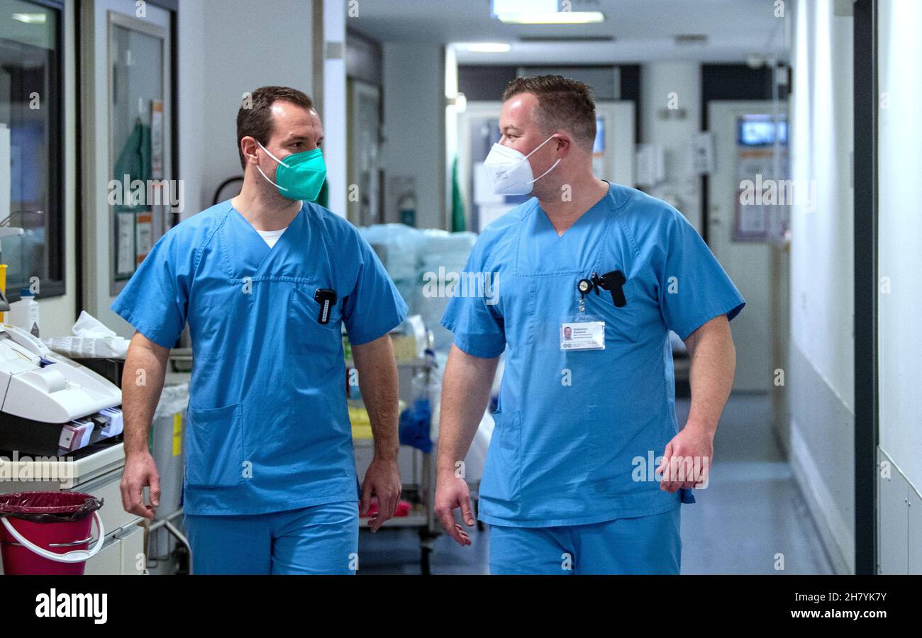 22. November 2021, Sachsen-Anhalt, Halle (Saale): Lorenz Homeister (l), Oberarzt und Intensivmediziner, und Sebastian Kasseck, Intensivkrankenschwester und Pflegeflächenmanager, sprechen auf der Intensivstation Corona am Universitätsklinikum Halle/Saale. Das Krankenhaus ist ein Zentrum der Behandlung von Covid 19 Patienten in der Region. (To dpa ''IT's Cruel' - harte Arbeit auf der Corona Intensivstation') Foto: Hendrik Schmidt/dpa-Zentralbild/dpa Stockfoto