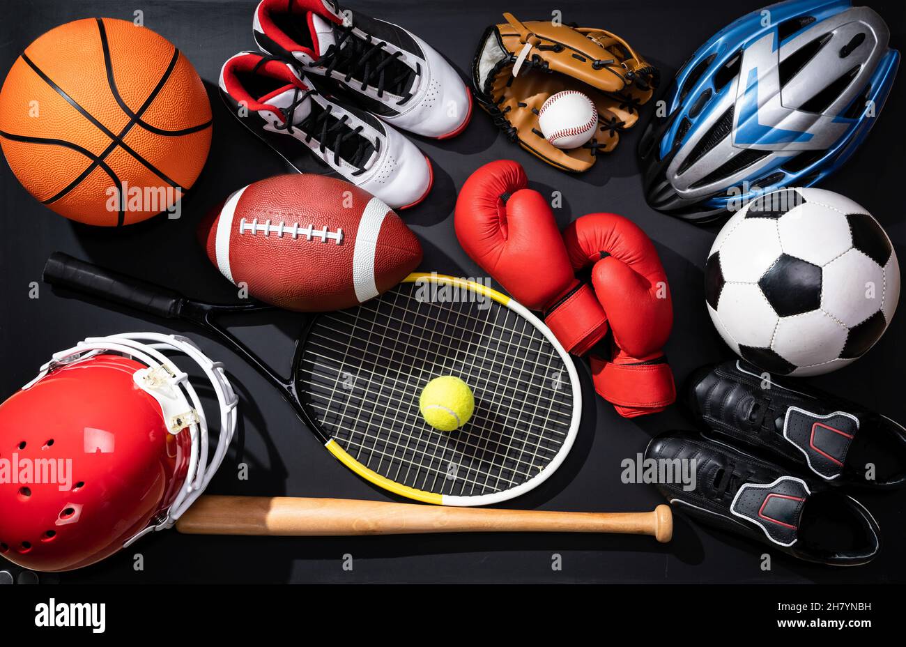 Hohe Betrachtungswinkel von verschiedenen Sportgeräten auf schwarzem Hintergrund Stockfoto