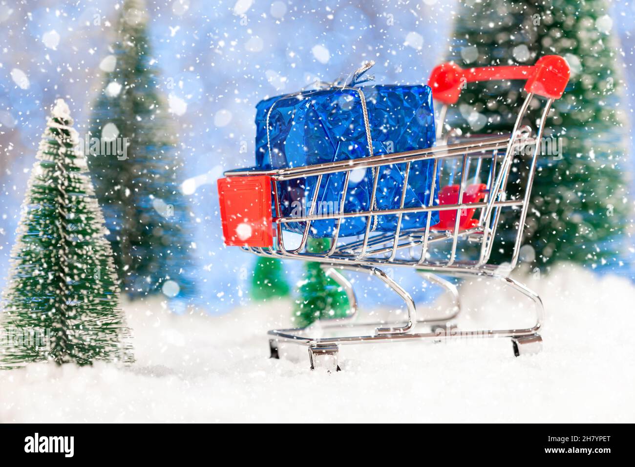weihnachtseinkäufe, Geschenkeinkäufe, Supermarkt-Korb auf dem Schnee, Konzept Stockfoto